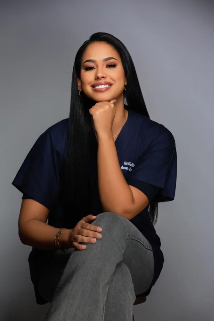 Docteur Noor, médecin brune en blouse bleu nuit, souriante et posant avec assurance – Sahiya Method